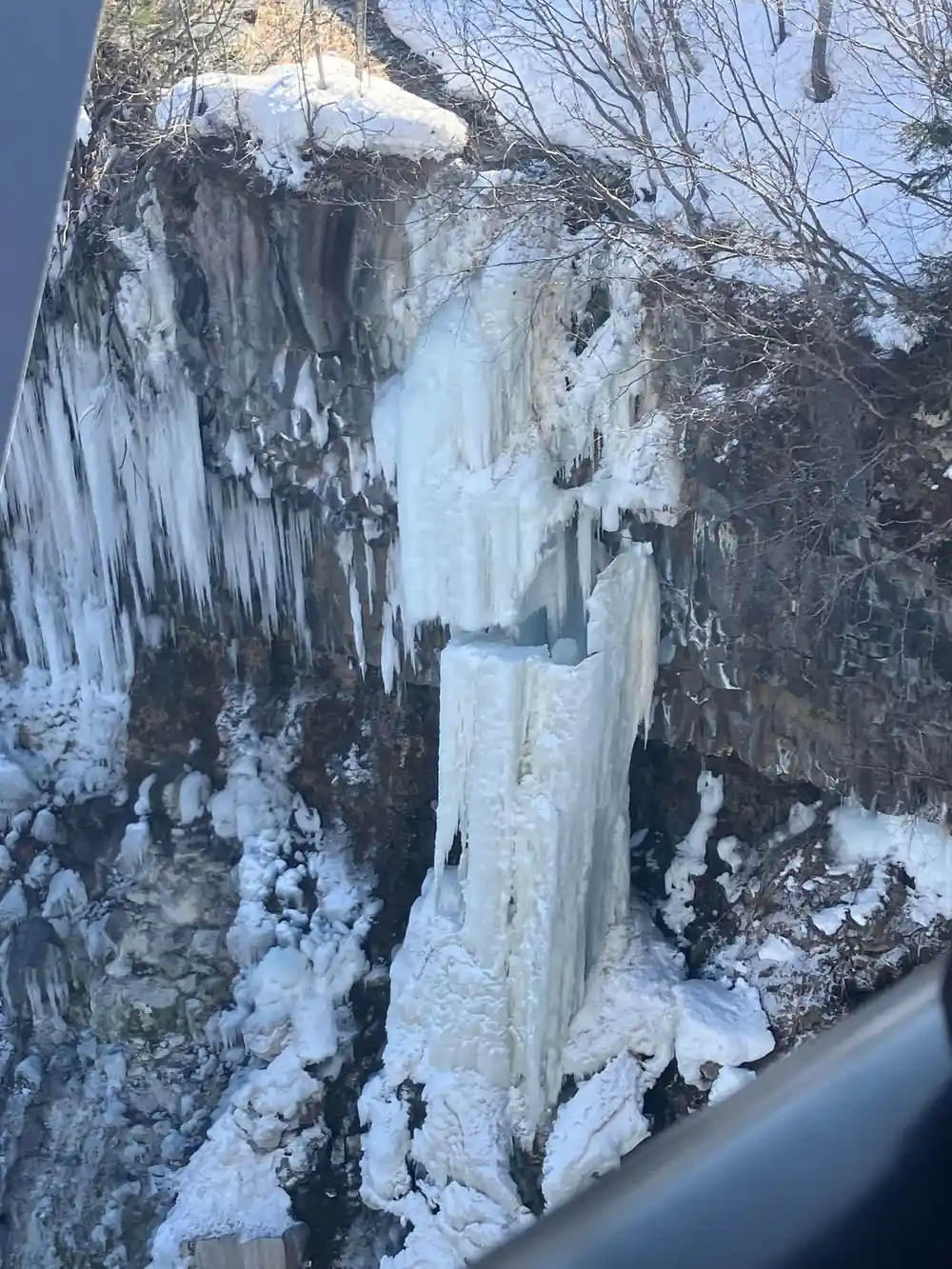 Frozen waterfall cascading down rocky cliff face