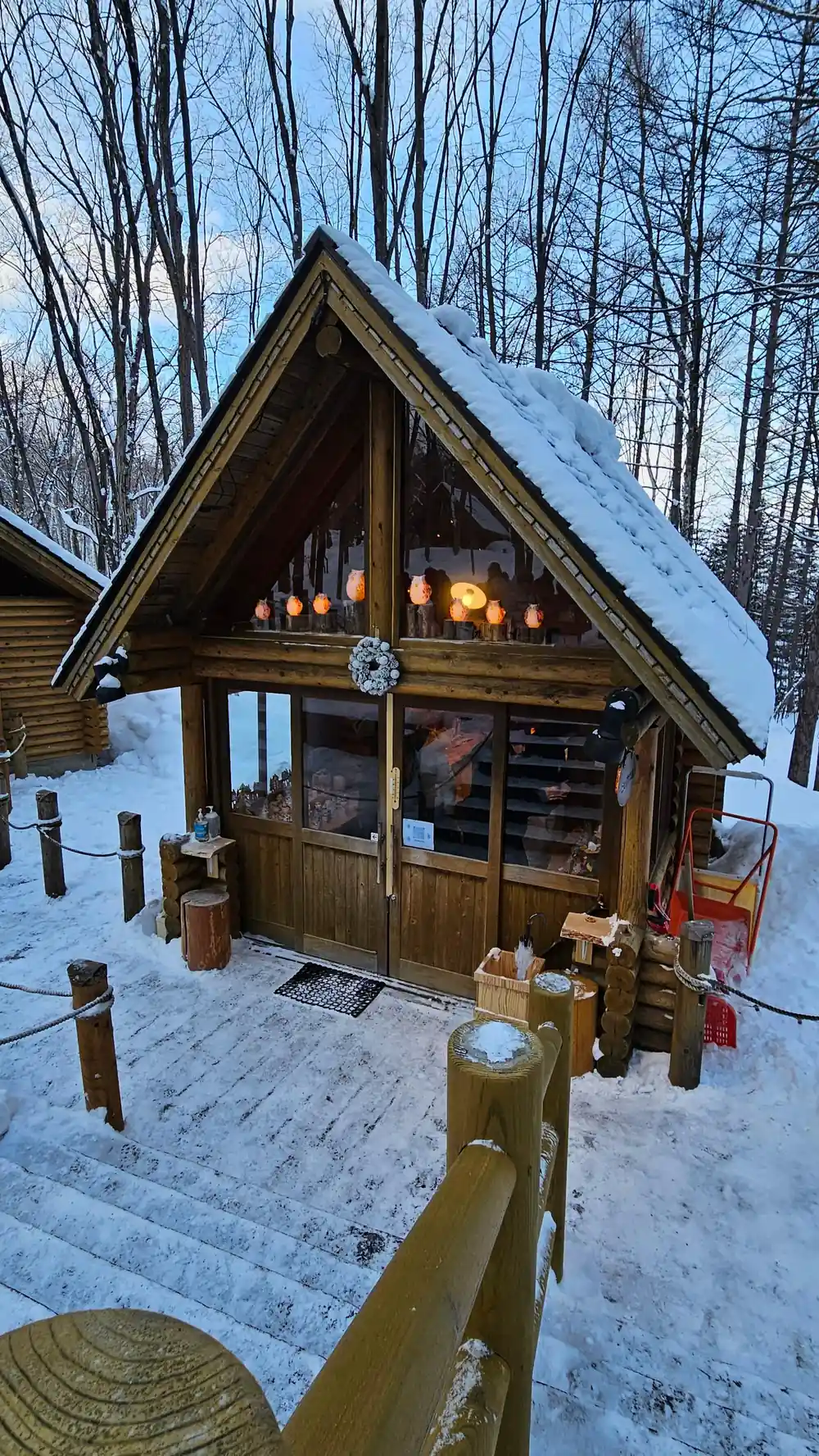 Wooden cabin with glowing windows in snowy forest